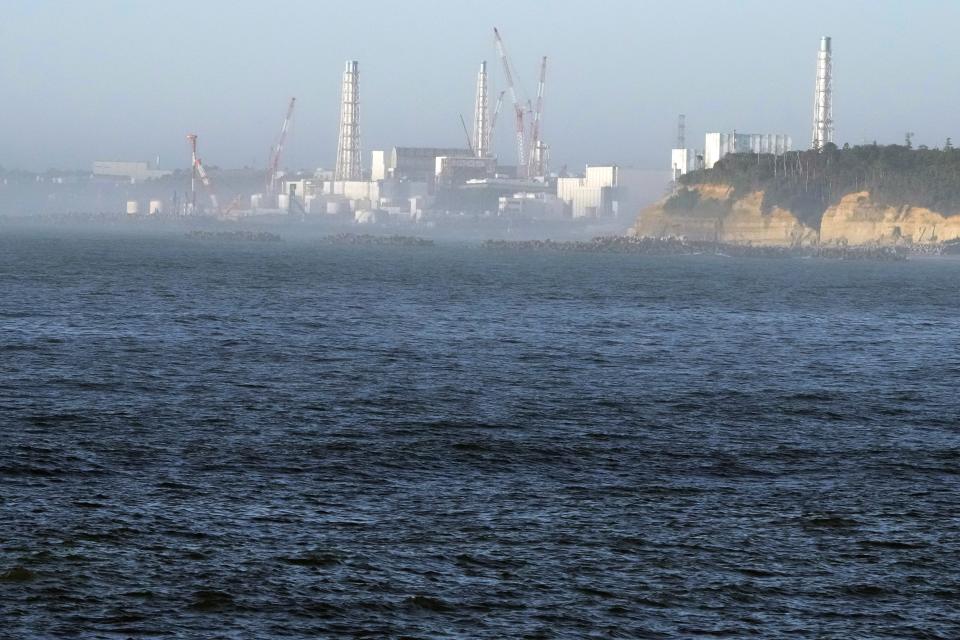 La central nuclear de Fukushima Daiichi, dañada por un enorme terremoto y un tsunami el 11 de marzo de 2011, se ve desde el cercano puerto pesquero de Ukedo en la localidad de Namie, nordeste de Japón, el jueves 24 de agosto de 2023.(AP Foto/Eugene Hoshiko)