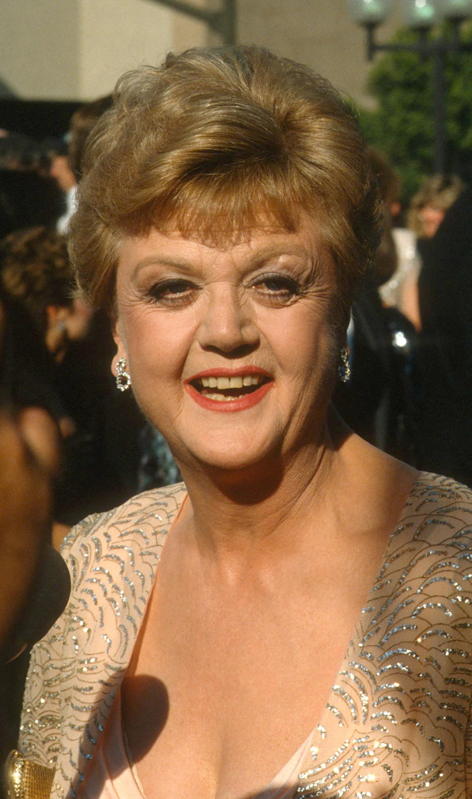 Angela Lansbury sourit dans une robe perlée lors d'un événement