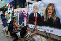 Children from an art school make paintings of U.S. President Donald Trump ahead of his India visit, in Mumbai, India, Friday, Feb. 21, 2020. Trump is scheduled to visit India Feb. 24-25. (AP Photo/Rajanish Kakade)