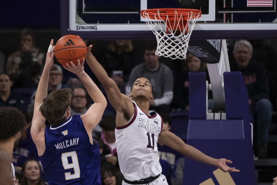 Gonzaga's Nolan Hickman, right, blocks a shot by Washington's Paul Mulcahy during the first half of an NCAA college basketball game Saturday, Dec. 9, 2023, in Seattle. (AP Photo/Stephen Brashear)