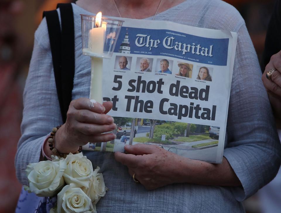 A women holds the June 29, 2018 edition of the Capital Gazette newpaper during a candlelight vigil on June 29 to honor the 5 people who were shot and killed the day before in Annapolis, Maryland.  Jarrod Ramos of Laurel Md. Has been arrested and charged with killing 5 people at the daily newspaper. 