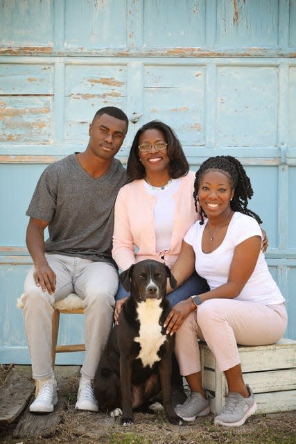 The family of Topeka USD 501 superintendent Tiffany Anderson and their dog, a black Labrador retriever mix named Belle.
