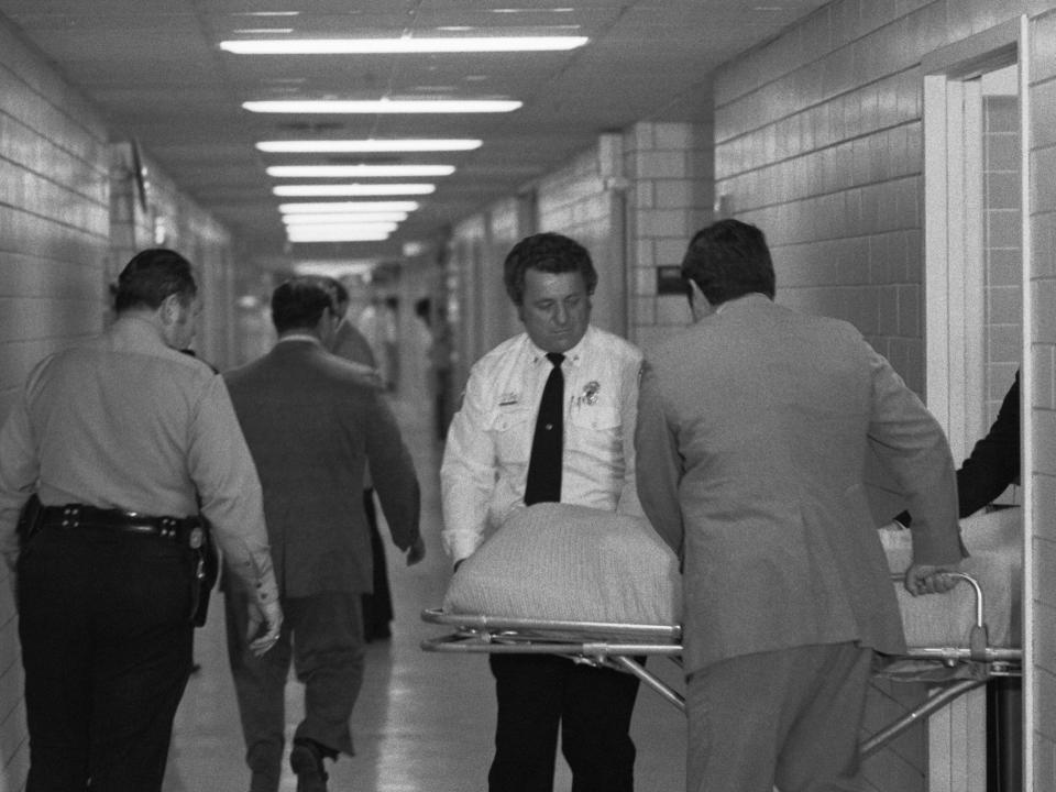 The body of billionaire Howard Hughes is wheeled out of the pathology department of Methodist Hospital where an autopsy disclosed kidney failure as the cause of death.