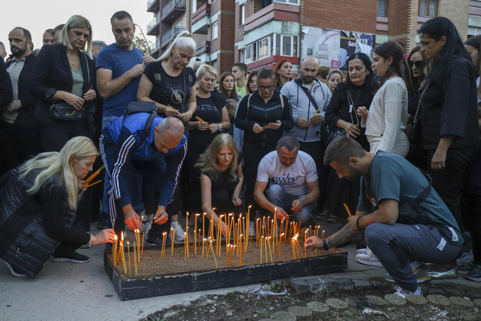 People light candles for the three killed Serbs in northern Serb-dominated part of ethnically divided town of Mitrovica, Kosovo, Tuesday, Sept.26, 2023. A Kosovo Serb party proclaimed three days of mourning starting Tuesday in Serb-dominated northern Kosovo for the three killed Serb assailants. Serbia's president demanded Tuesday to have a NATO-led peacekeeping force take over for the national law enforcement agency in northern Kosovo after a daylong shootout between armed Serbs and Kosovar police left one officer and three gunmen dead. (AP Photo/Bojan Slavkovic)