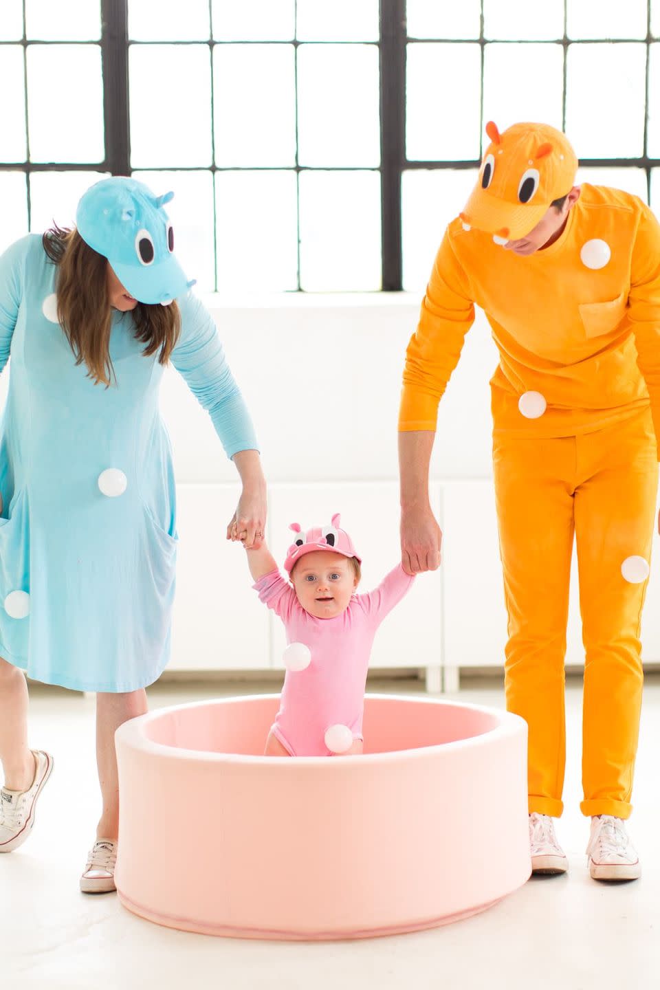 <p>No need to permanently alter your baseball hats or dress (and onesie!) — you can remove these white ball pit balls and felt hippo eyes when you're done. </p><p><em><a href="https://sugarandcloth.com/our-family-diy-hungry-hippos-costume-idea/" rel="nofollow noopener" target="_blank" data-ylk="slk:See full tutorial on Camille Styles »;elm:context_link;itc:0;sec:content-canvas" class="link ">See full tutorial on Camille Styles »</a></em></p>