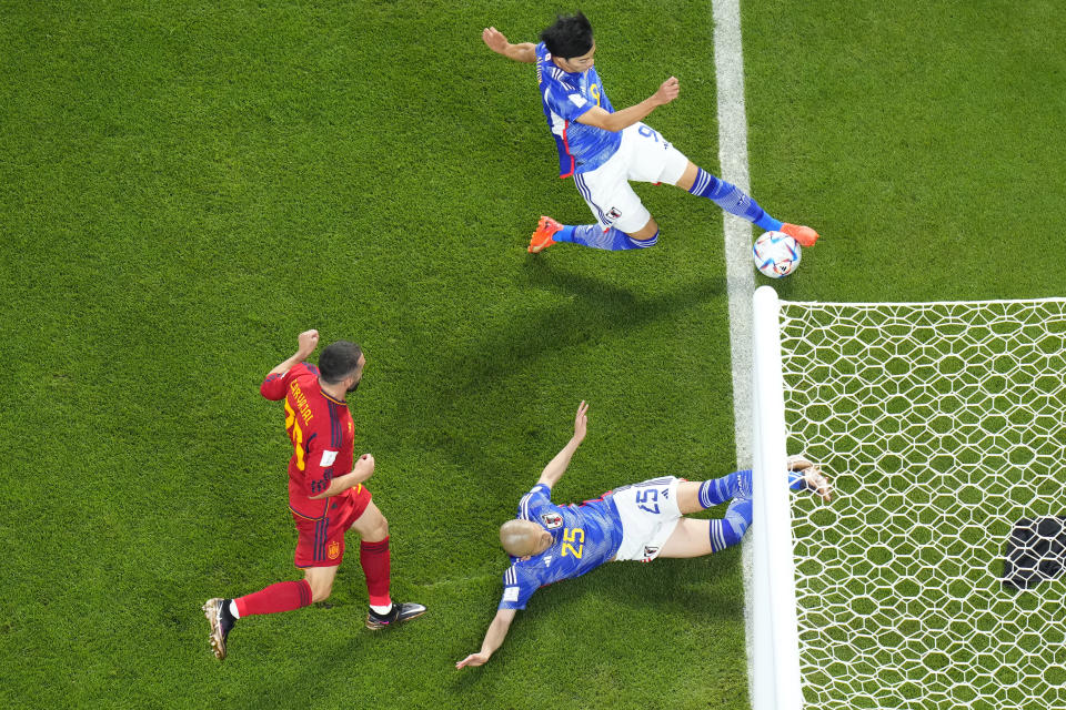 Japan's Kaoru Mitoma appears to have the ball over the line before crossing it for a goal during the World Cup group E soccer match between Japan and Spain, at the Khalifa International Stadium in Doha, Qatar, Thursday, Dec. 1, 2022. (AP Photo/Petr David Josek)