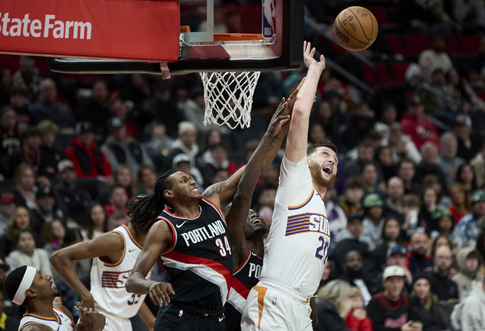 Phoenix Suns center Jusuf Nurkic, right, and Portland Trail Blazers forward Jabari Walker (34) reach for a rebound during the second half of an NBA basketball game in Portland, Ore., Sunday, Jan. 14, 2024. (AP Photo/Craig Mitchelldyer)