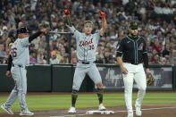 Detroit Tigers' Kerry Carpenter (30) celebrates after his two-run triple as he stands between Tigers third base coach Joey Cora (56) and Arizona Diamondbacks third base Eugenio Suárez, right, during the third inning of a baseball game Friday, May 17, 2024, in Phoenix. (AP Photo/Ross D. Franklin)