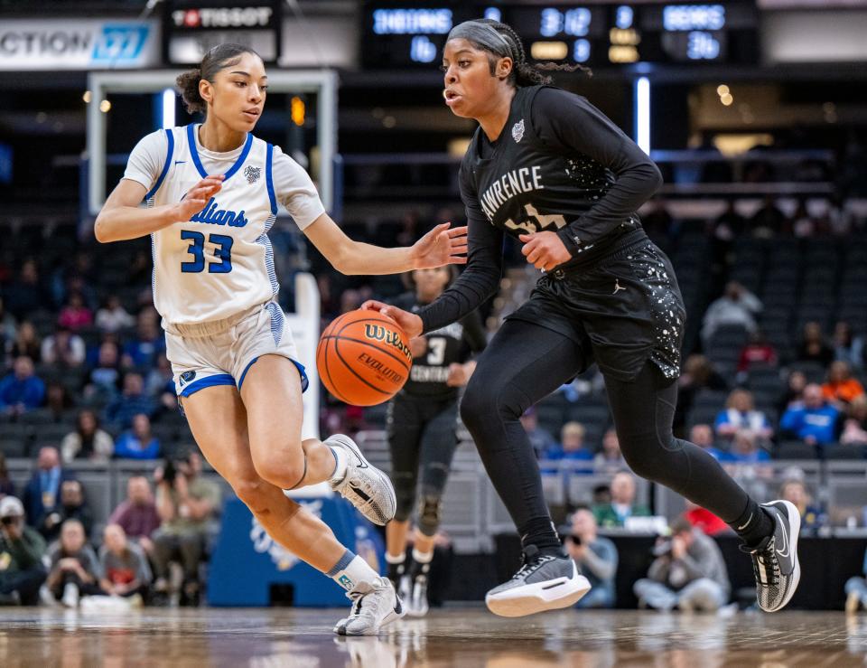 Lawrence Central High School junior Laila Abdurraqib (44) drives the ball into the defense of Lake Central high School senior Aniyah Bishop (33) during the second half of an IHSAA class 4A girls’ basketball state finals game, Saturday, Feb. 24, 2024, at Gainbridge Fieldhouse, in Indianapolis. Lawrence Central won the school’s first state championship title in girl’s basketball.