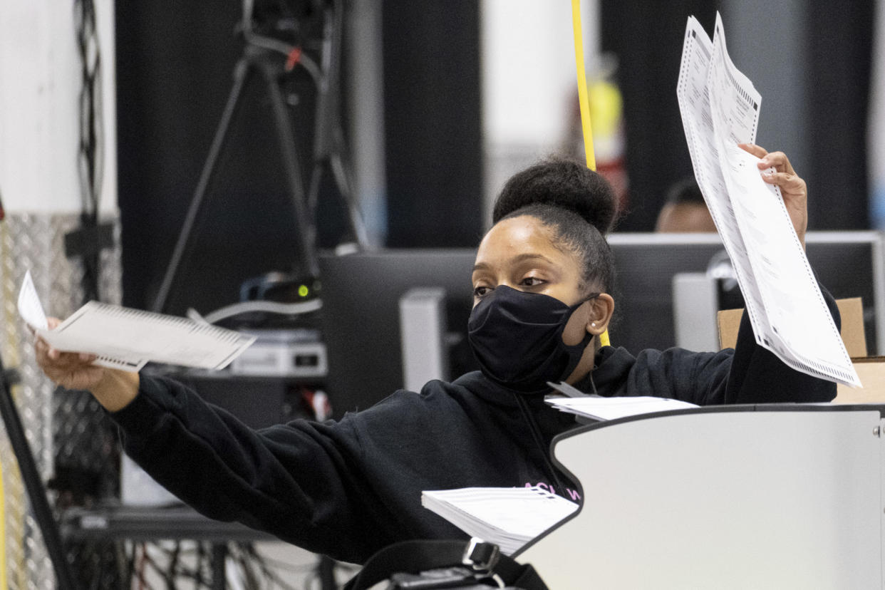 A worker scans ballots as the presidential recount process gets under way Tuesday afternoon, Nov. 24, 2020 in the DeKalb County, Ga. (AP Photo/Ben Gray)
