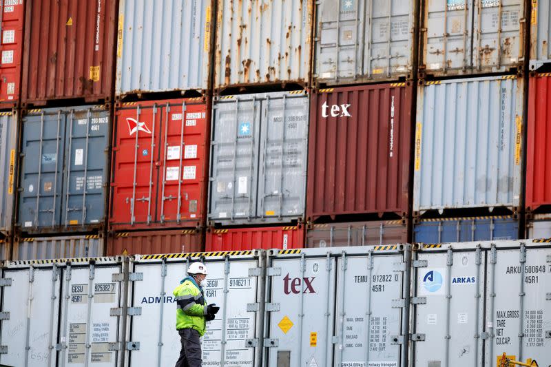 A dockworker wearing a mask is seen near containers as he works at port in Ashdod, Israel