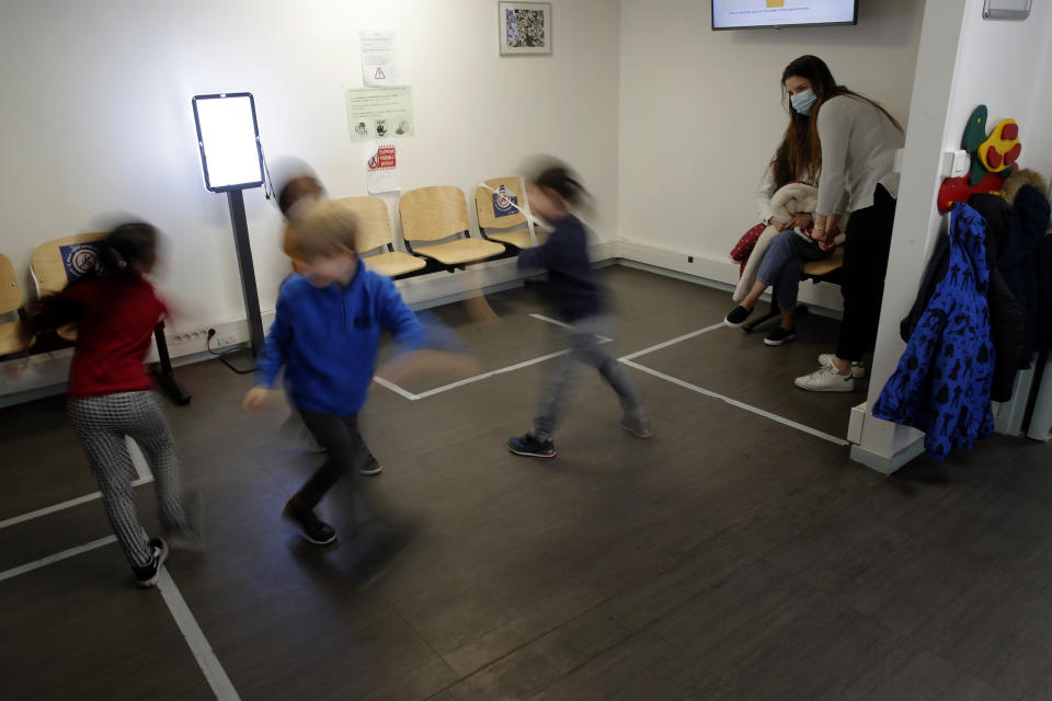 Nurse Sarah Merlin looks at children in the pediatric unit of the Robert Debre hospital, in Paris, France, Tuesday, March 2, 2021. (AP Photo/Christophe Ena)