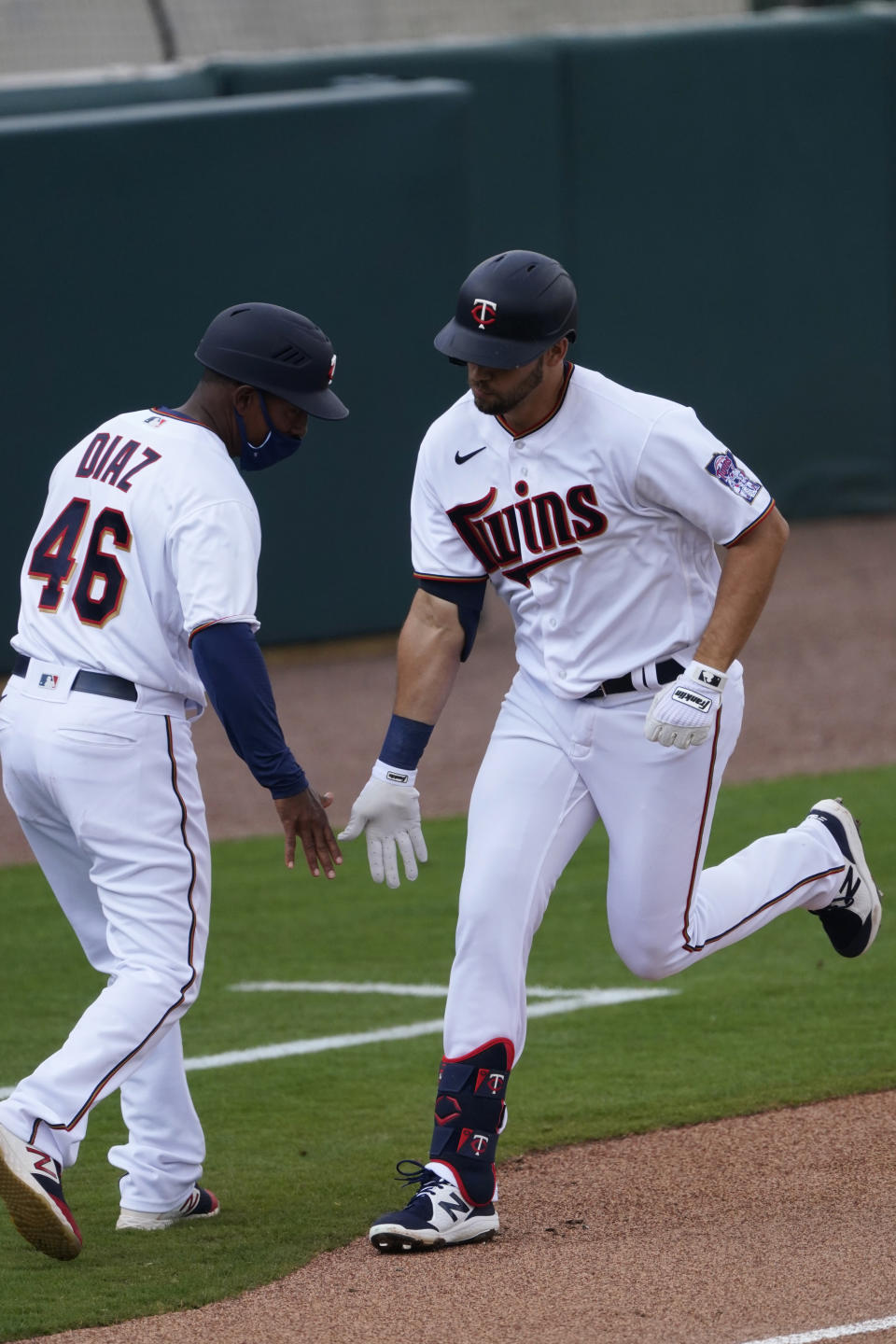 Minnesota Twins right fielder Alex Kirilloff celebrates with third base coach Tony Diaz (46) after hitting a home run in the second inning of a spring training baseball game against the Boston Red Sox Thursday, March 11, 2021, in Fort Myers, Fla.. (AP Photo/John Bazemore)