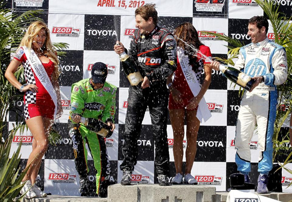 Simon Pagenaud, right, of France, sprays champagne on Will Power, center, of Australia, next to James Hinchcliffe, left, of Canada, after the IndyCar Series' Toyota Grand Prix of Long Beach auto race, Sunday, April 15, 2012, in Long Beach, Calif. Power took first, Pagenaud second and Hinchcliffe third. (AP Photo/Richard Vogel)