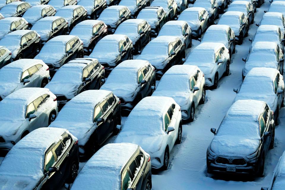 Snow-covered vehicles sit in a rental car parking lot at the O'Hare International Airport in Chicago, Sunday, Jan. 14, 2024.