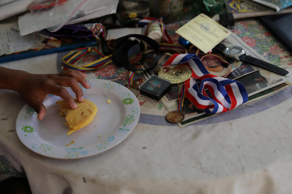 Baseball little league player Adrian Salcedo, 13, eats an arepa for breakfast at his home in Maracaibo, Venezuela. (Photo: Manaure Quintero/Reuters)