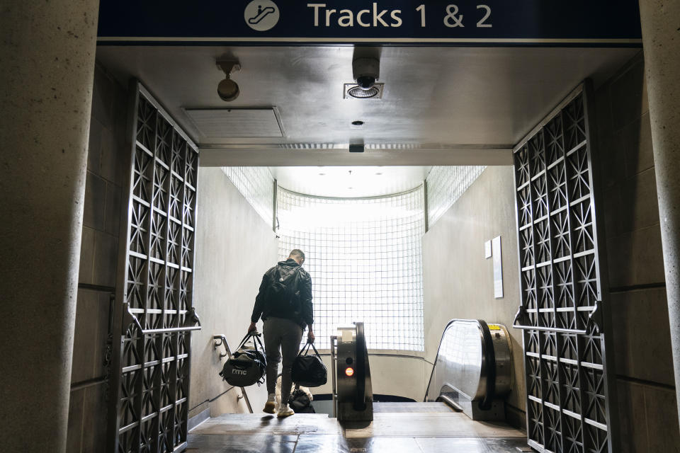 A passenger descends a staircase to board an Amtrak train, Friday, Nov. 20, 2020, in Providence, R.I. With the coronavirus surging out of control, the nation's top public health agency pleaded with Americans not to travel for Thanksgiving and not to spend the holiday with people from outside their household. (AP Photo/David Goldman)