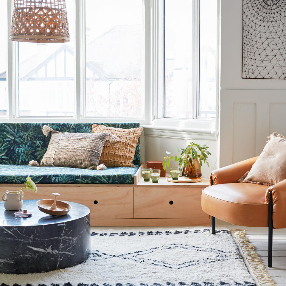 Living room with built-in seating under sofa in bay window area