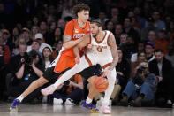 Illinois' Josh Ogundele, left, defends against Texas' Timmy Allen (0) during the second half of the team's NCAA college basketball game in the Jimmy V Classic, Tuesday, Dec. 6, 2022, in New York. (AP Photo/John Minchillo)