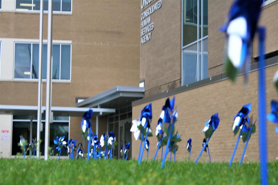 In observance of Child Abuse Prevention Month, Onslow Department of Social Services wore blue on Thursday, April 1, 2021, and gathered around the flag pole at the Consolidated Human Services Building to create a Pinwheel Garden.