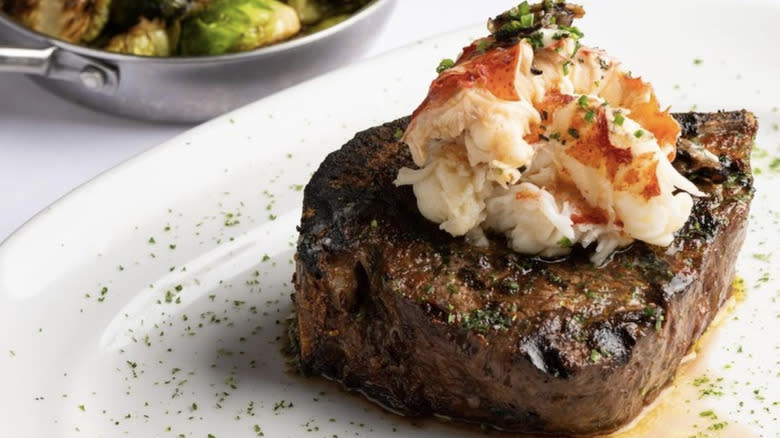 Steak topped with lobster and herbs