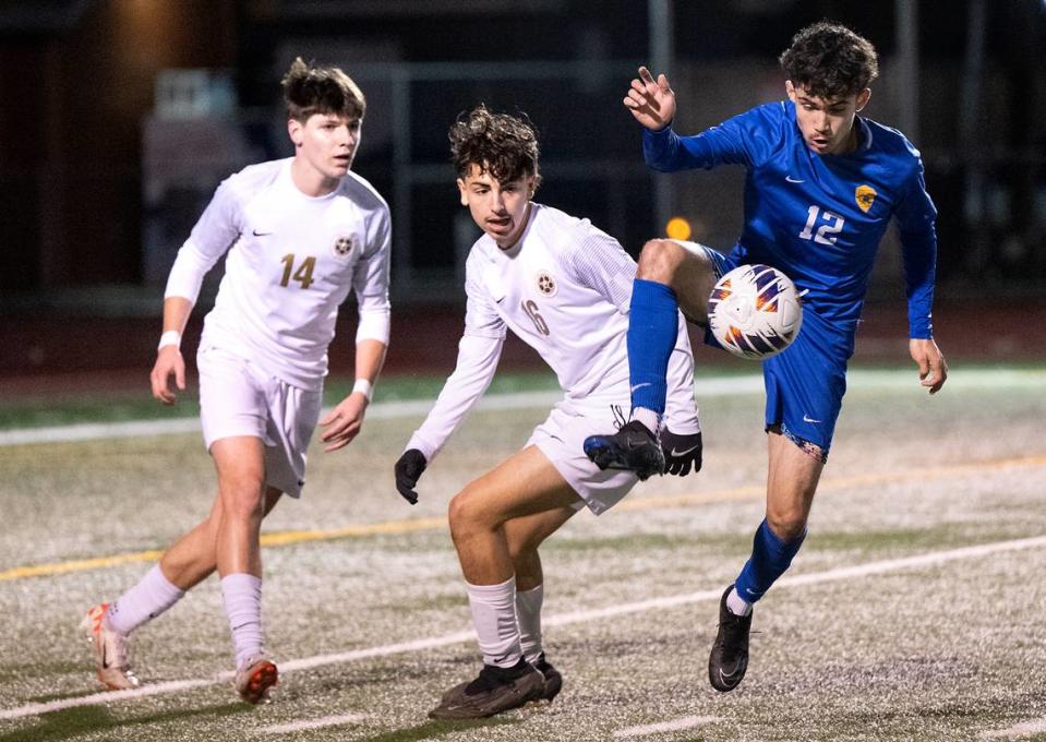 Turlock’s Luis Llamas controls the ball in front of Enochs’ Xavier Martinez (16) and Aiden Redfern (14) during the Central California Athletic League game at Turlock High School in Turlock, Calif., Wednesday, Jan. 24, 2024. Turlock won the game 2-1.