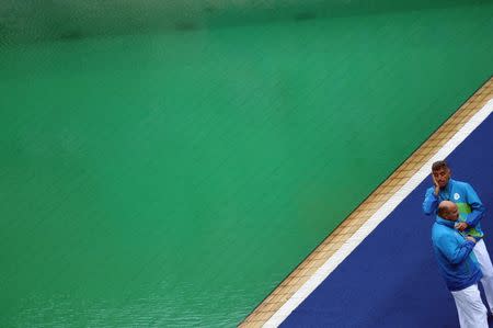 2016 Rio Olympics - Water Polo - Preliminary - Men's Preliminary Round - Group B France v USA - Maria Lenk Aquatics Centre - Rio de Janeiro, Brazil - 10/08/2016. Referees Nenad Peris (CRO) of Croatia and Mark Koganov (AZE) of Azerbaijan stand on the side of the pool where water turned green. REUTERS/Kai Pfaffenbach