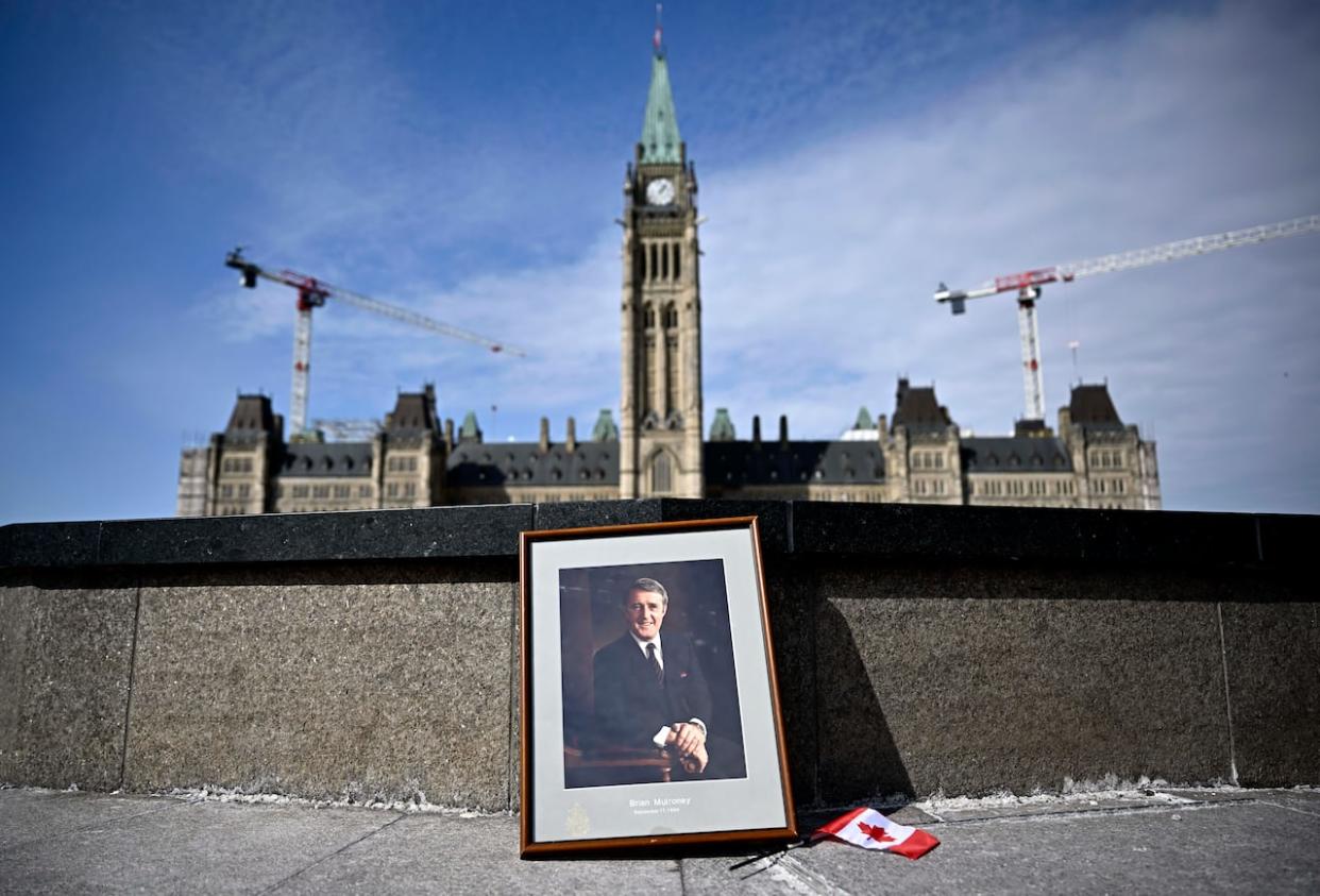 A framed portrait of former prime minister Brian Mulroney leans against the Centennial Flame on Parliament Hill in Ottawa on Friday, March 1, 2024. (Justin Tang/Canadian Press - image credit)