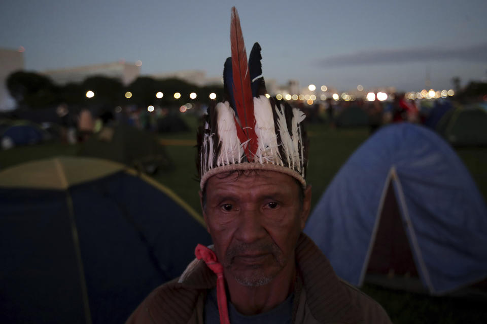 A Gaviao indigenous man rises at sunrise during an annual three-day campout protest known as the Free Land Encampment, in Brasilia, Brazil, Wednesday, April 24, 2019. The event begins amid animosity between Brazil’s indigenous groups and the new government of far-right President Jair Bolsonaro. (AP Photo/Eraldo Peres)