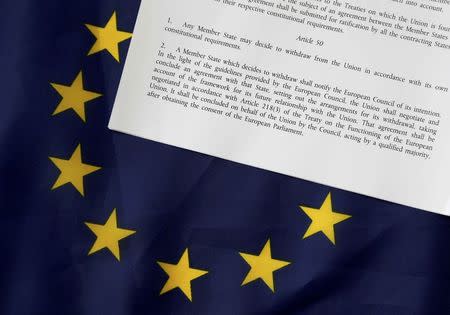 FILE PHOTO - Article 50 of the EU's Lisbon Treaty that deals with the mechanism for departure is pictured with an EU flag following Britain's referendum results to leave the European Union, in this photo illustration taken in Brussels, Belgium, June 24, 2016. REUTERS/Francois Lenoir/Illustration/File Photo