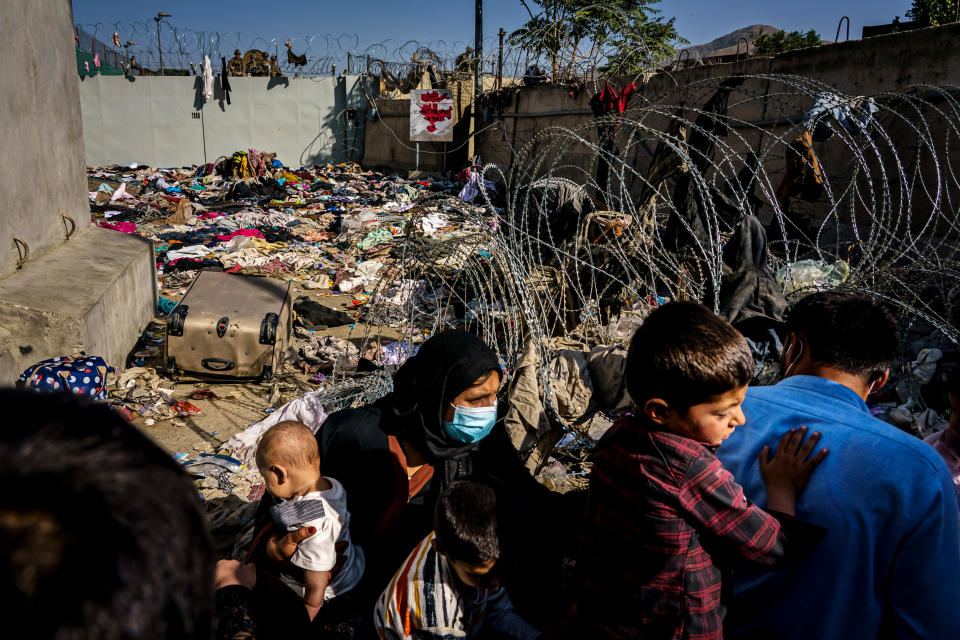 Image: A family near a barred off gate at the airport in Kabul, Afghanistan, on Aug. 25, 2021. (Marcus Yam / Los Angeles Times via Getty Images)