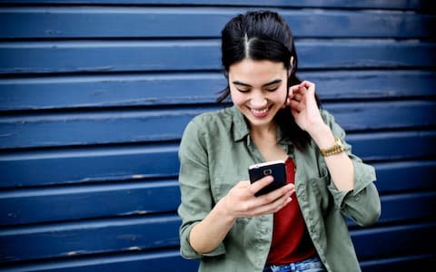 A woman holding a smartphone - Credit: Alys Tomlinson/Cultura RM 