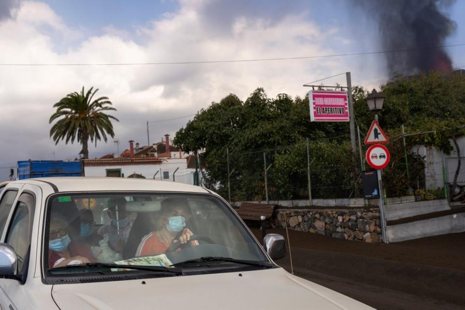 Residents leave their house in La Mancha on the island of La Palma in the Canaries (AP)