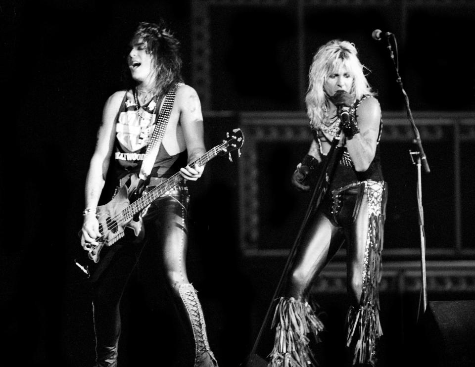 Lead singer Vince Neil, right, urges the crowd onward while bassist Nikki Sixx lays on the rhythm during Motley Crue sold-out concert at Municipal Auditorium July 7, 1987.