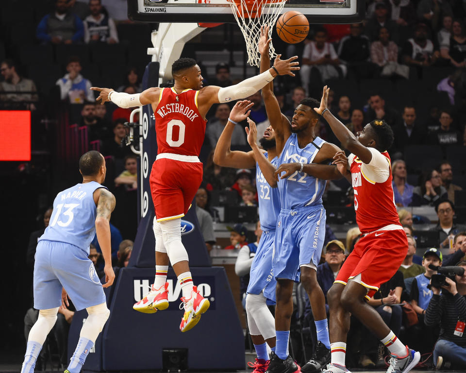 Houston Rockets guard Russell Westbrook (0) passes behind his back to center Clint Capela, right, as Minnesota Timberwolves center Karl-Anthony Towns (32), forward Andrew Wiggins (22) and guard Shabazz Napier (13) look on during the first half of an NBA basketball game Friday, Jan. 24, 2020, in Minneapolis. (AP Photo/Craig Lassig)