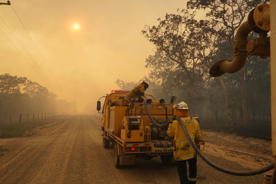 Pictured is a firefighter next to a tanker in the Queensland bushfires. 