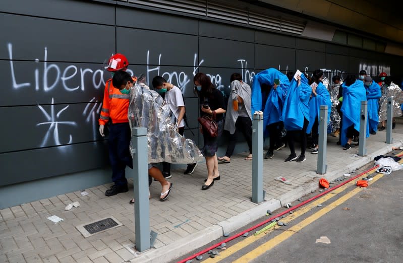 Protesters leave the Hong Kong Polytechnic University campus to surrender to police, in Hong Kong