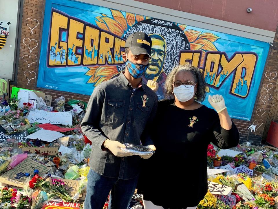 Volunteers Matthew and Andrena Seawood, son and mother, pose in front of artwork honoring George Floyd in Minneapolis. (Photo: Courtesy of Andrena Seawood)