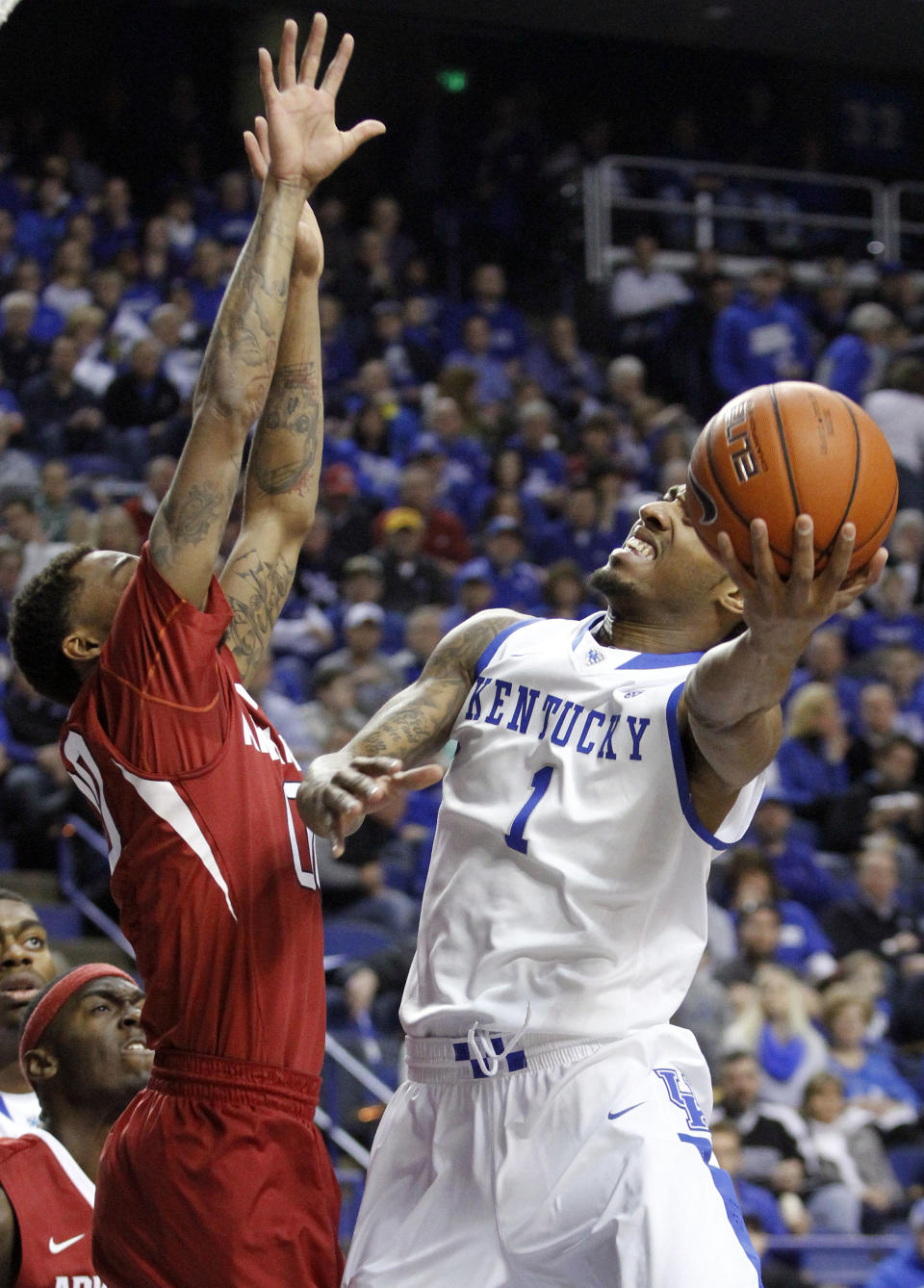 Kentucky's James Young (1) shoots as Arkansas' Rashad Madden defends during the first half of an NCAA college basketball game Thursday, Feb. 27, 2014, in Lexington, Ky. (AP Photo/James Crisp)