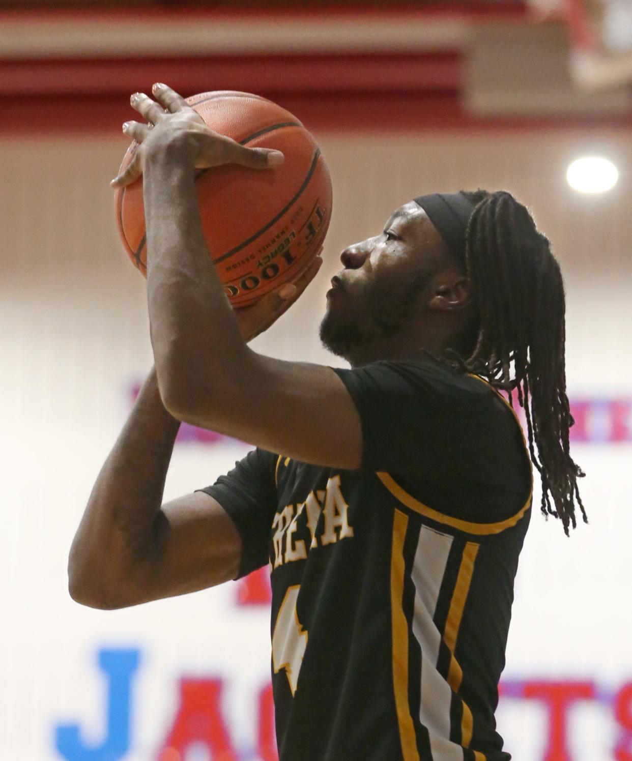 Athena's Zacarr Johnson takes aim and sinks a three point shot from the corner in the first quarter.