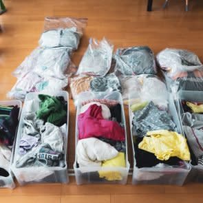 Woman organizes clothes in living room of her home