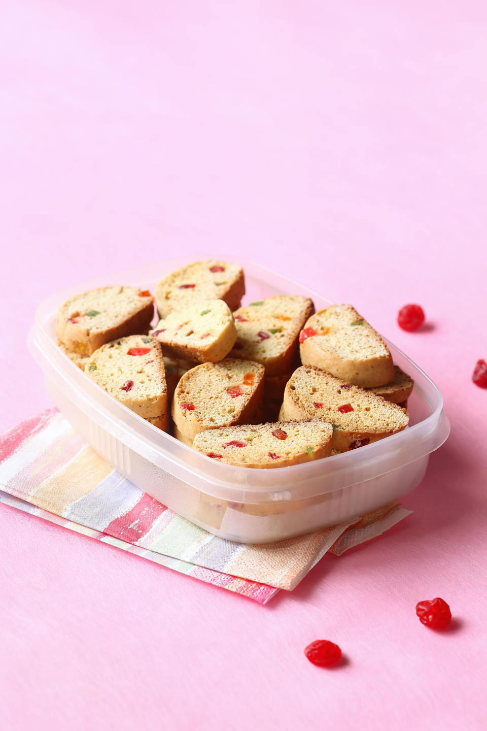 Traditional Italian Biscotti with Candied Fruits in a  box, on light pink background.