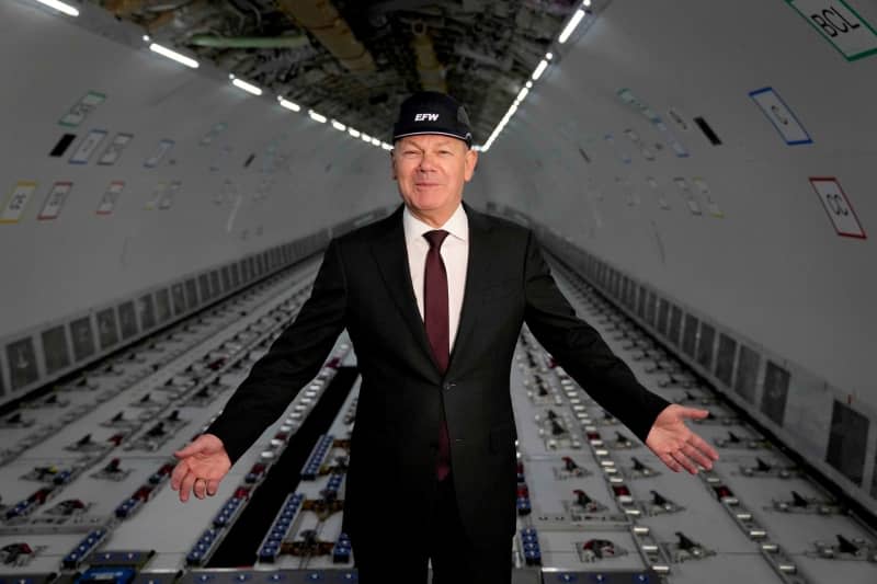 Germany's Chancellor Olaf Scholz stands in an airplane during his visit to Elbe Aircraft Factory. Ebrahim Noroozi/AP Pool/dpa