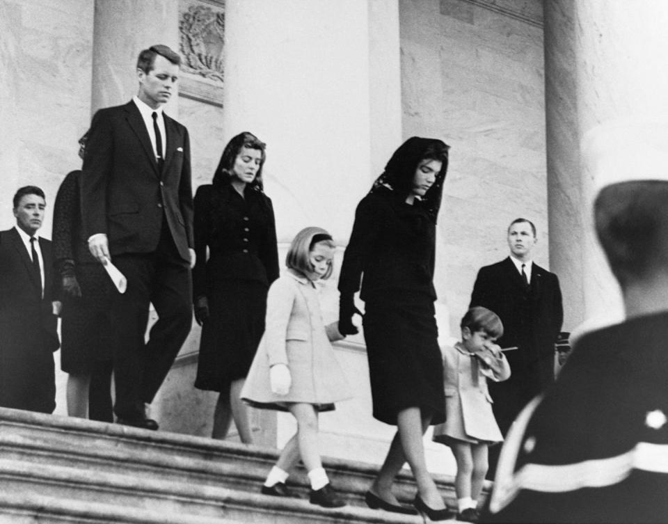<p>Jacqueline Kennedy, with John Jr. and Caroline, leaves the White House for a service at the Capitol honoring her slain husband.</p>