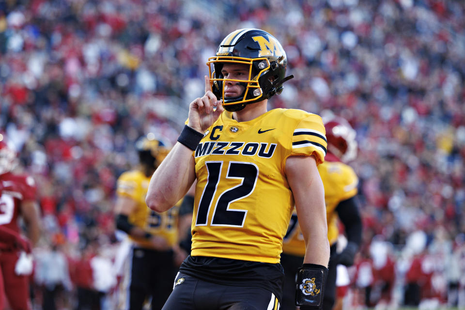 FAYETTEVILLE, ARKANSAS - NOVEMBER 24: Brady Cook #12 of the Missouri Tigers signals to the crowd after running the ball in for a touchdown in the first half of the game against the Arkansas Razorbacks at Donald W. Reynolds Razorback Stadium on November 24, 2023 in Fayetteville, Arkansas. (Photo by Wesley Hitt/Getty Images)