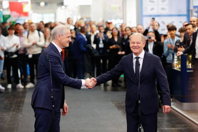 Jonas Gahr Store (L), Prime Minister of Norway, shakes hands with German Chancellor Olaf Scholz after the opening tour at the Hannover Messe. Moritz Frankenberg/dpa