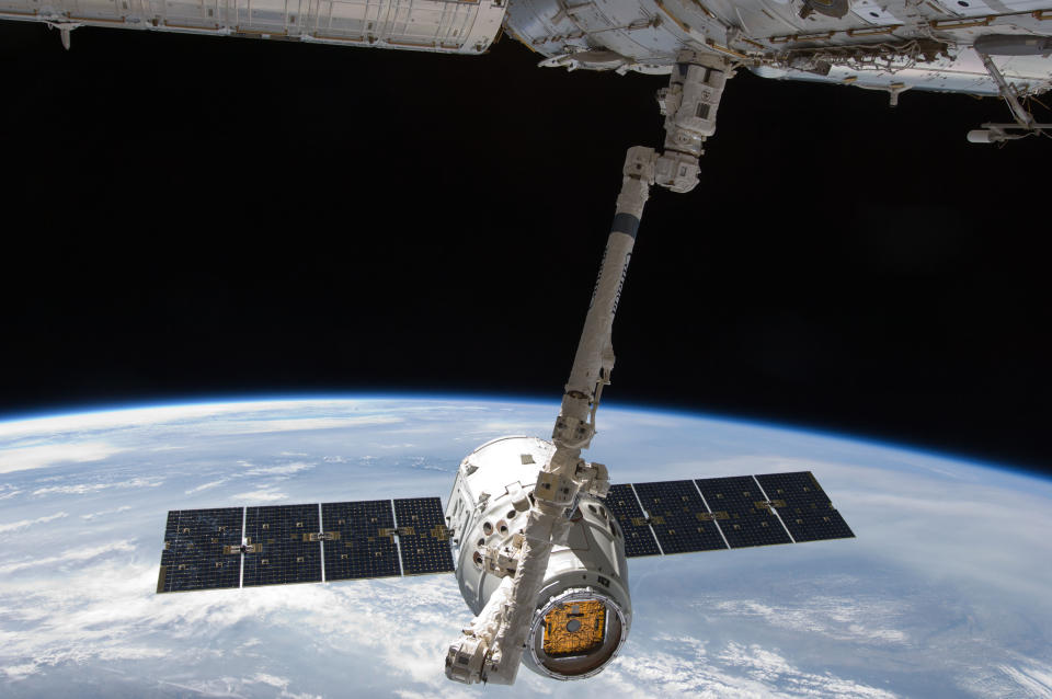 The SpaceX Dragon commercial cargo craft is grappled by the Canadarm2 robotic arm at the International Space Station in this May 25, 2012 NASA handout photo.  The capsule -- carrying 3,100 pounds of science samples and other equipment --  made a parachute splashdown into the Pacific Ocean May 21, 2015, wrapping up a five-week stay at the International Space Station. REUTERS/NASA/Handout via Reuters