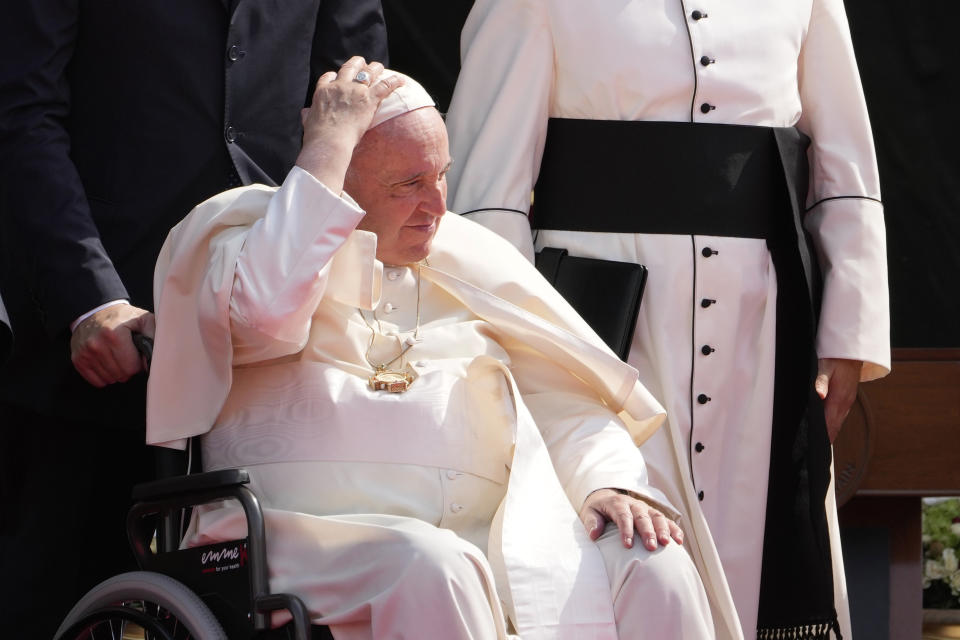 Pope Francis holds on to his skull cap during the closing session of the "Bahrain Forum for Dialogue: East and west for Human Coexistence," at the Al-Fida square at the Sakhir Royal palace, Bahrain, Friday, Nov. 4, 2022. Pope Francis is making the Nov. 3-6 visit to participate in a government-sponsored conference on East-West dialogue and to minister to Bahrain's tiny Catholic community, part of his effort to pursue dialogue with the Muslim world. (AP Photo/Hussein Malla)