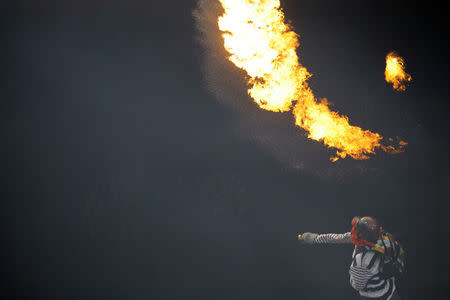 A demonstrator throws a molotov cocktail during a rally against Venezuela's President Nicolas Maduro in Caracas, Venezuela. REUTERS/Carlos Barria