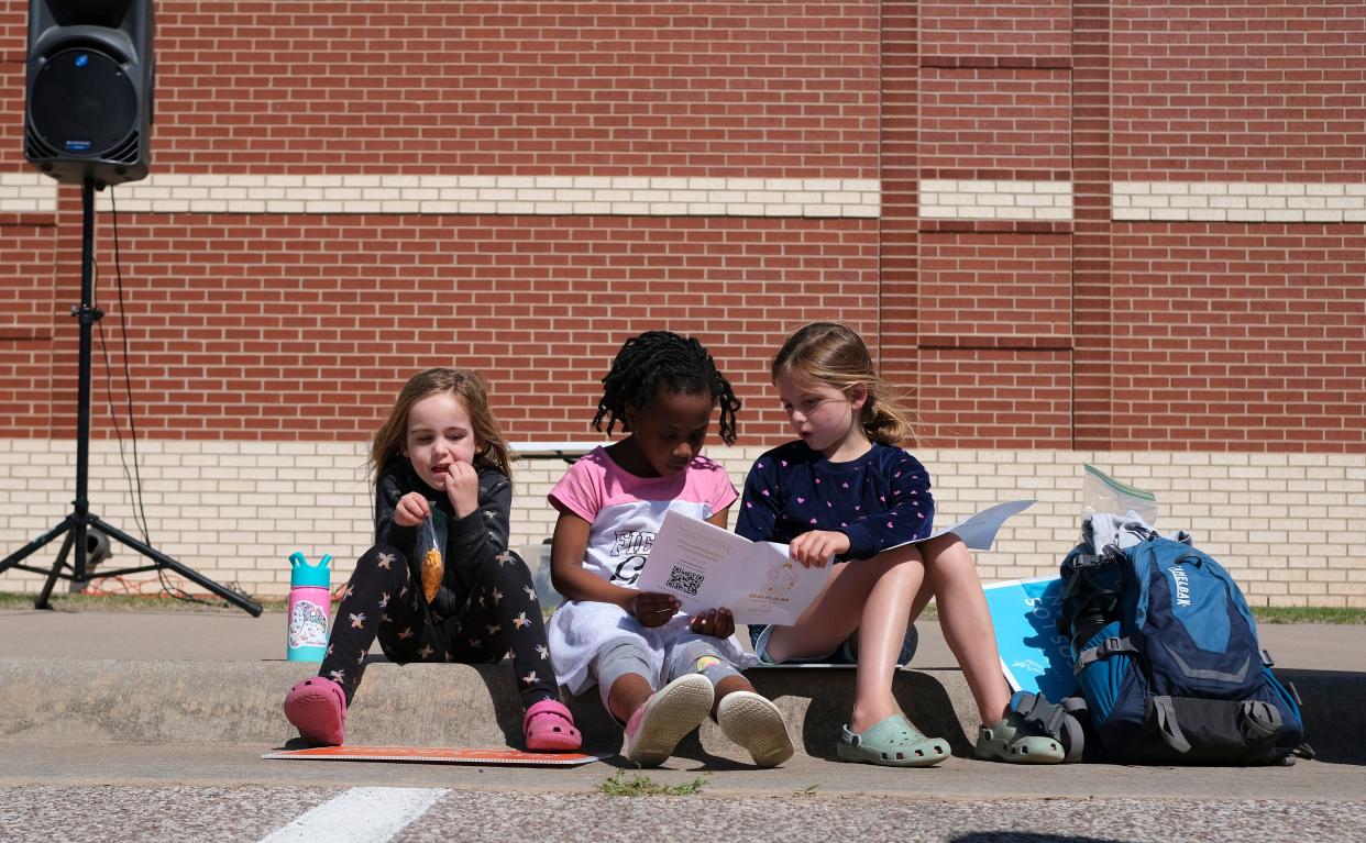 Young girls sit on a curb reading the prayer guide before the march at the Dream Peace Walk in Oklahoma City from Douglass High School to the Bridge Impact Youth Center, to celebrate the anniversary of Dr. Rev. Martin Luther King, Jr's Letters from Birmingham,  Sunday, April 16, 2023.